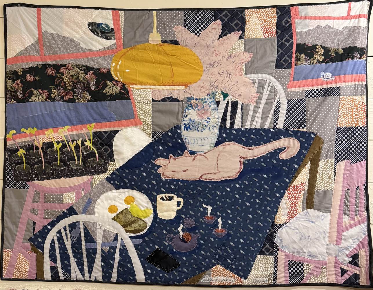 Hand-quilted textile: UFO Sighting — a domestic table with a cat, breakfast and cut flowers, and a UFO in the window.
